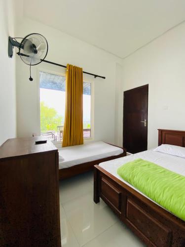 a bedroom with two beds and a window at TK Homes in Badulla