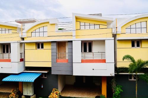 a building with yellow and white at Siesta Inn - RP Resort in Chennai