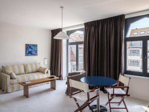 a living room with a couch and a table at Cozy Getaway for 4 near the Beach in Knokke-Heist