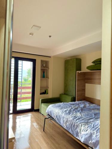 a bedroom with a bed and a sliding glass door at Mountain View Apartment Near Ski Slopes Gudauri in Kʼumlistsʼikhe