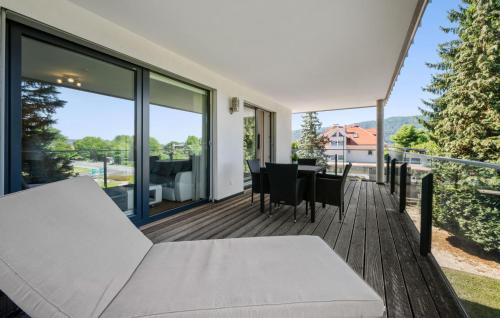 a balcony with a table and chairs on a wooden deck at Ferienwohnung Pörtschach 90M² in Pörtschach am Wörthersee