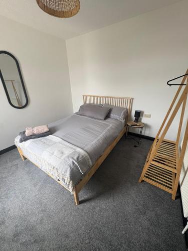 a bed in a bedroom with a wooden frame at Refurbished 4-Bed Home Near Hospital & Station in Chatham