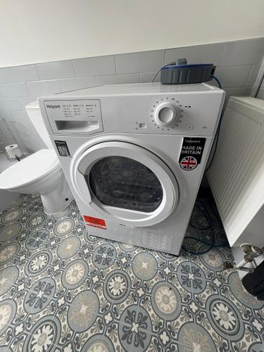 a washing machine in a bathroom with a toilet at Refurbished 4-Bed Home Near Hospital & Station in Chatham