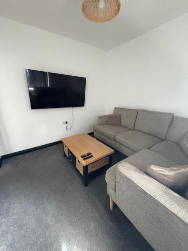 a living room with a couch and a flat screen tv at Refurbished 4-Bed Home Near Hospital & Station in Chatham
