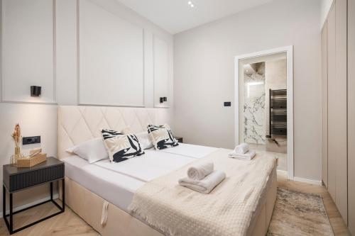 Un dormitorio blanco con una cama grande con toallas. en Marvie Apartments, en Rijeka