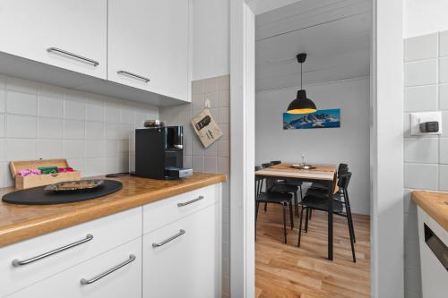 a kitchen with white cabinets and a small table at Ferienwohnung 'Bergkristall' in Schiers