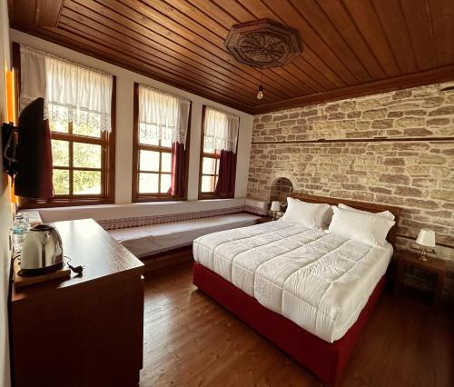 a bedroom with a bed and a brick wall at Kalemi Twin Boutique Hotel in Gjirokastër