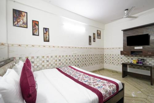 a bedroom with a bed and a tv on the wall at Hotel South Delhi Inn Just 10 Minute Away Form Nizamuddin Railway Station in New Delhi