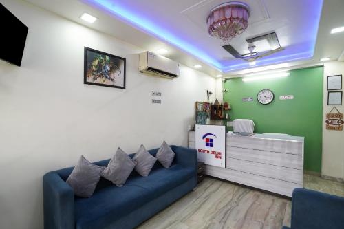 a living room with a blue couch in a room at Hotel South Delhi Inn Just 10 Minute Away Form Nizamuddin Railway Station in New Delhi