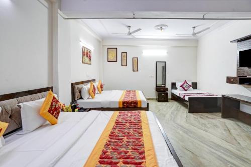 a hotel room with two beds and a couch at Hotel South Delhi Inn Just 10 Minute Away Form Nizamuddin Railway Station in New Delhi
