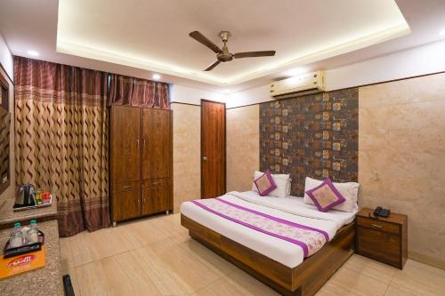 a bedroom with a bed and a ceiling fan at Hotel South Delhi Inn Just 10 Minute Away Form Nizamuddin Railway Station in New Delhi