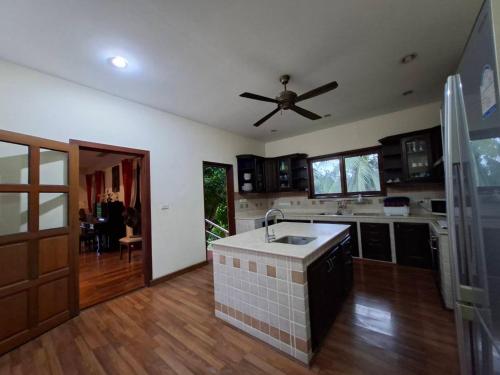 a kitchen with a sink and a ceiling fan at Exclusive 10-Person Villa with Pool & land 6000m in Ban Hui Yai Muk
