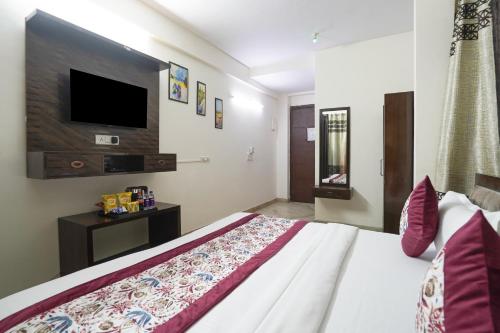 a bedroom with a bed with a tv on the wall at Hotel South Delhi Inn Just 10 Minute Away Form Nizamuddin Railway Station in New Delhi