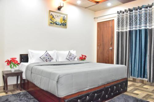 a bedroom with a large bed and a wooden door at City Central Inn Hotel !! in Kasauli