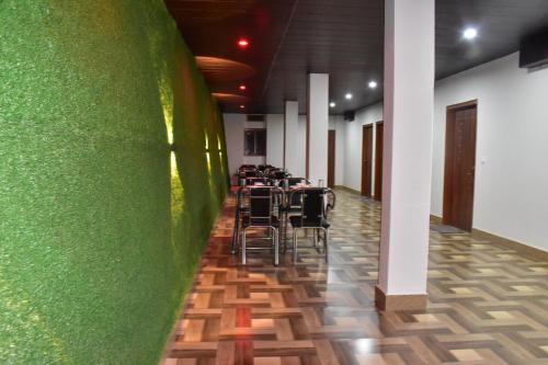 a room with a green wall with tables and chairs at City Central Inn Hotel !! in Kasauli