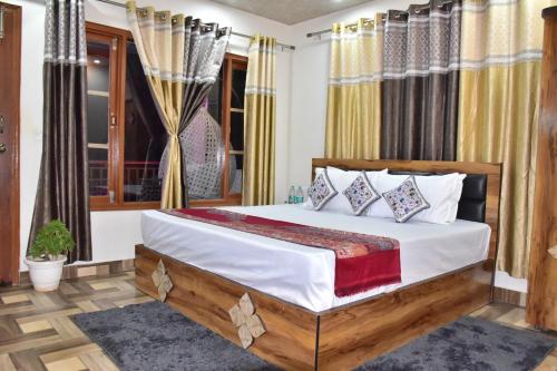 a bedroom with a bed with white sheets and pillows at City Central Inn Hotel !! in Kasauli