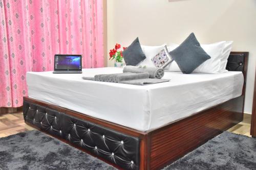a large bed with a laptop on top of it at City Central Inn Hotel !! in Kasauli