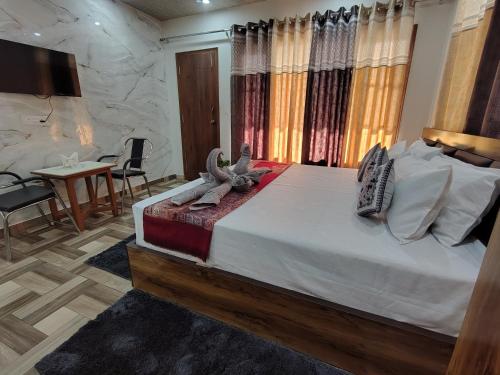 a bedroom with a large bed and a table and chairs at City Central Inn Hotel !! in Kasauli