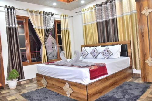 a bedroom with a bed with white sheets and pillows at City Central Inn Hotel !! in Kasauli