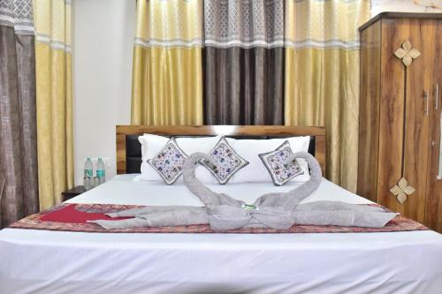 a bed with two swans made out of towels at City Central Inn Hotel !! in Kasauli