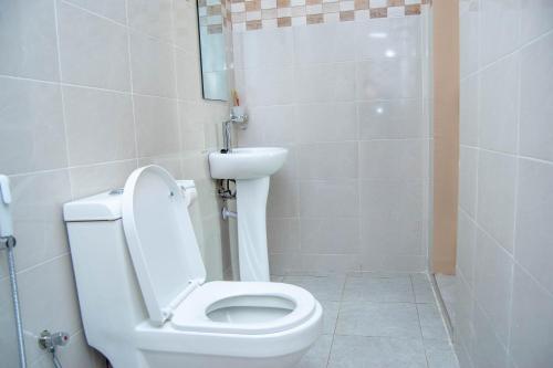 a bathroom with a white toilet and a shower at Mamucha Grand Lodge in Arusha