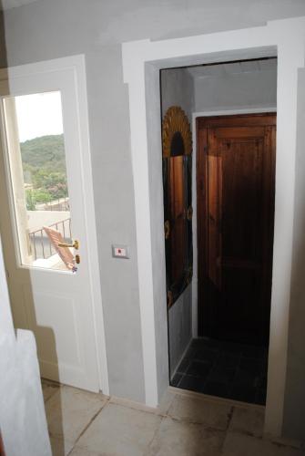 a hallway with a door and a window with a view at La Coloniale San Pantaleo in San Pantaleo