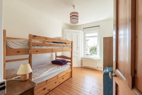 une chambre avec deux lits superposés et une lampe dans l'établissement Villa Louise 100m2 proche centre et plage, à Wimereux
