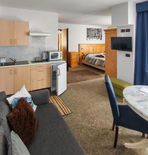 a living room with a couch and a kitchen and a bed at Shackleton Chalet in Sestriere