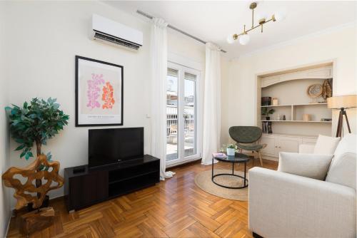 a living room with a couch and a television at Houseloft Metropolis Panorama in Thessaloniki