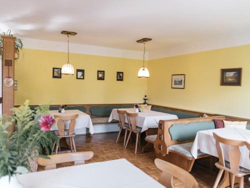 a restaurant with tables and chairs and yellow walls at Privatzimmer und Ferienwohnungen Gassner in Admont