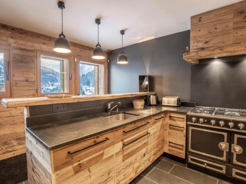 une cuisine avec un évier et une cuisinière dans l'établissement Chalet 5*, 5 chambres, SPA et sauna, proche pistes - FR-1-304-229, à La Clusaz