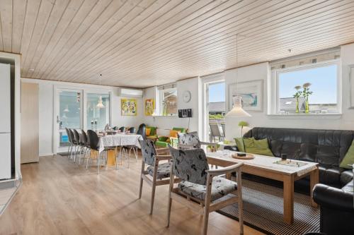 a living room with a table and chairs at Energy-Efficient Pool House Located Between The Sea And The Fjord in Ringkøbing