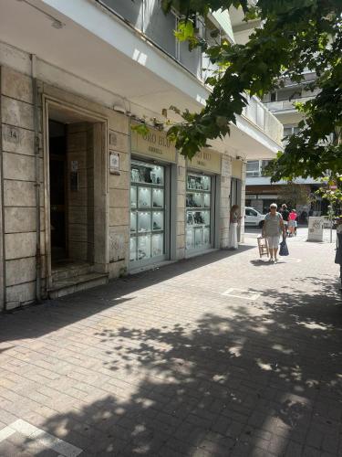 a woman walking down a sidewalk in front of a building at Grado 2 in Lido di Ostia
