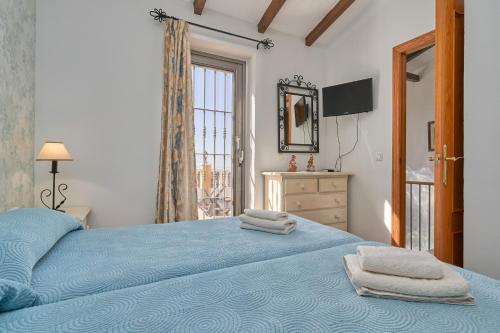 a bedroom with a blue bed with towels on it at Casa Torre del Manzano in Torrox