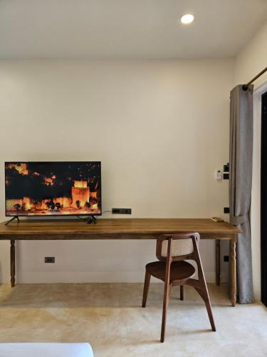 a wooden desk with a television on a wall at Phangan Utopia Resort in Mae Haad