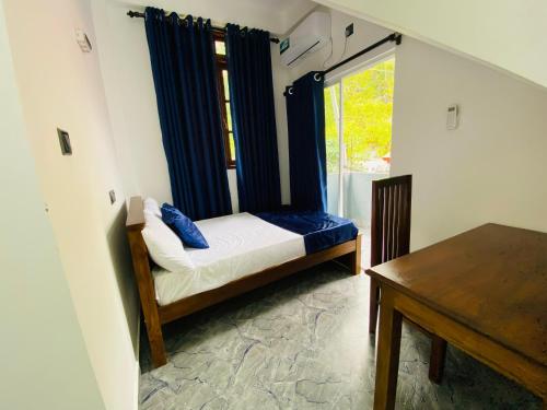 a small bedroom with a bed and a window at TK Homes in Badulla