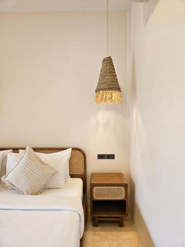 a bedroom with a bed with a table and a chandelier at Phangan Utopia Resort in Mae Haad