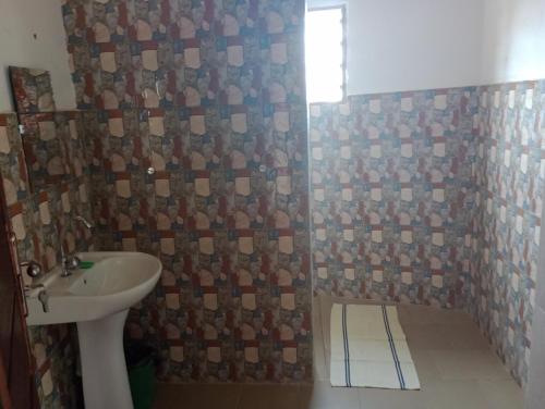 a bathroom with a sink and a shower at Keur Mamina in Warang