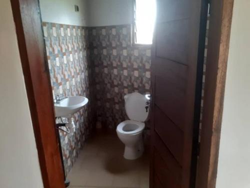 a bathroom with a toilet and a sink at Keur Mamina in Warang