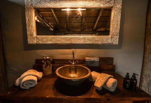 a bathroom with a sink and a mirror at South Okavango - Omogolo Hideaways in Rammu