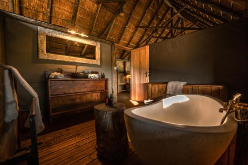 a bathroom with a bath tub in a room at South Okavango - Omogolo Hideaways in Rammu