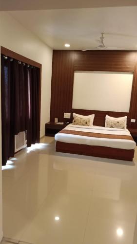 a bedroom with a large bed with a wooden headboard at Hotel Le castle in Jāmb