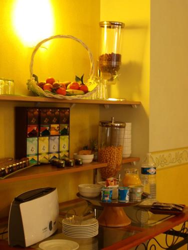 a kitchen with a counter with a bowl of fruit on a shelf at Hôtel Adour in Pau