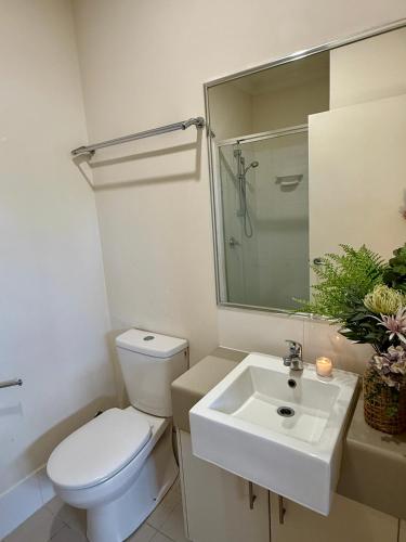 a bathroom with a white toilet and a sink at Aeris Luxe Stay in Perth