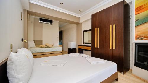 a bedroom with a white bed and a fireplace at Agathoupoli beach in Órmos Methónis