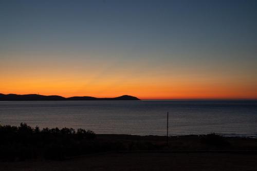 a sunset over the water with mountains in the background at Kallidimi's House in Monemvasia