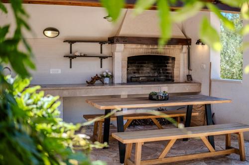 a kitchen with a table and a fireplace at Luxury Villa Nature with heated private pool, sauna & fire pit, a short walk to the beach in Milna