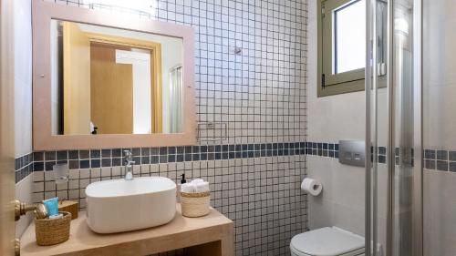 a bathroom with a sink and a toilet and a mirror at Kallidimi's House in Monemvasia