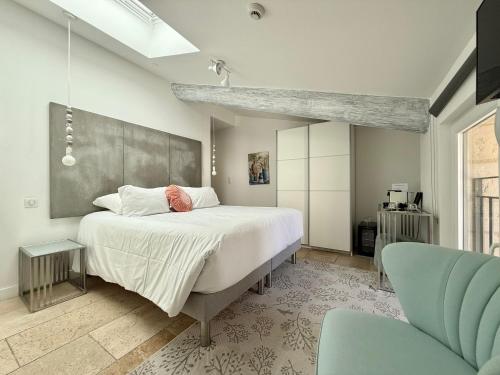 a bedroom with a large bed and a chair at Hotel Restaurant O'Banel in Gallargues-Le-Montueux