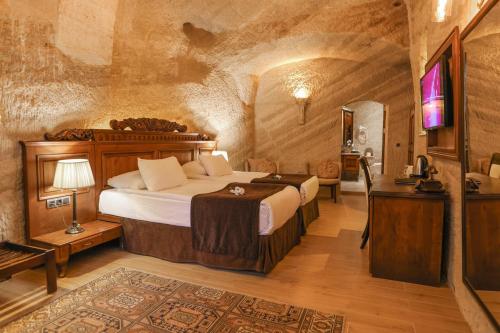 a bedroom with a bed and a tv in a room at Utopia Cave Cappadocia in Urgup